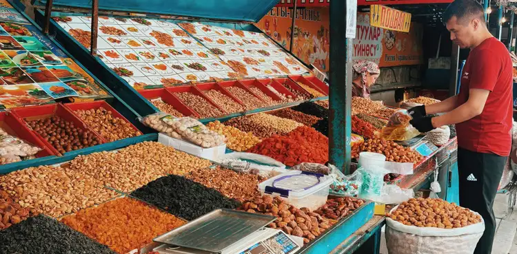 Voyage au Kirghizistan - Homme à son stand du bazar de Bichkek