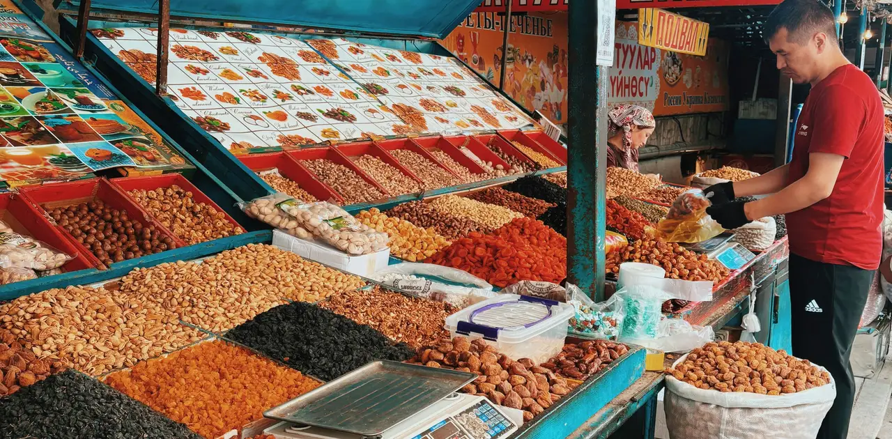 Voyage au Kirghizistan - Homme à son stand du bazar de Bichkek