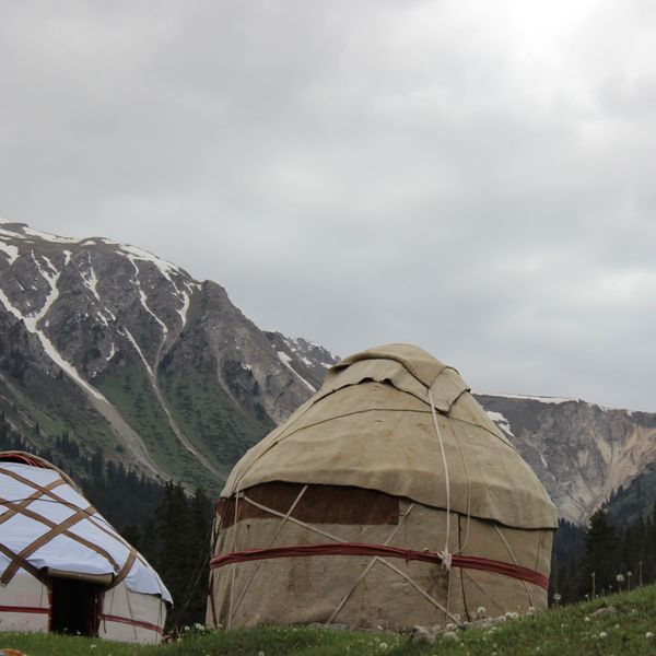 Voyage au Kirghizistan - 2 yourtes traditionnelles devant des sommets enneigés