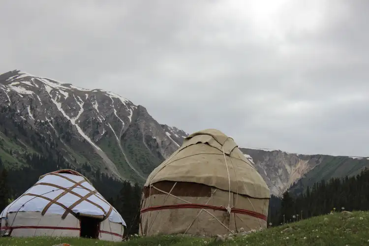 Voyage au Kirghizistan - 2 yourtes traditionnelles devant des sommets enneigés