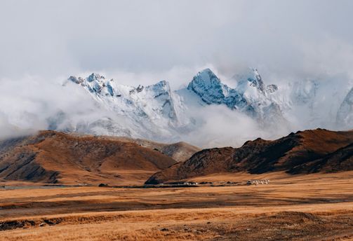 Voyage au Kirghizistan : Yourtes et montagnes enneigées en arrière-plan