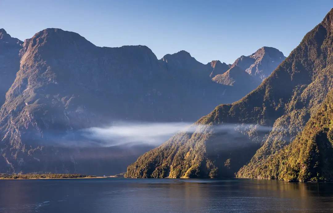 montagnes et du lac de Fiordland brumeux au lever du soleil