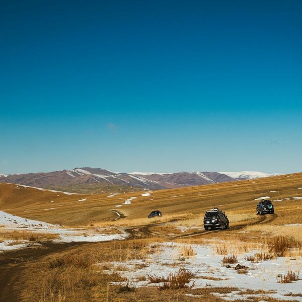 Plusieurs 4x4 sur une route de Mongolie, entre les steppes