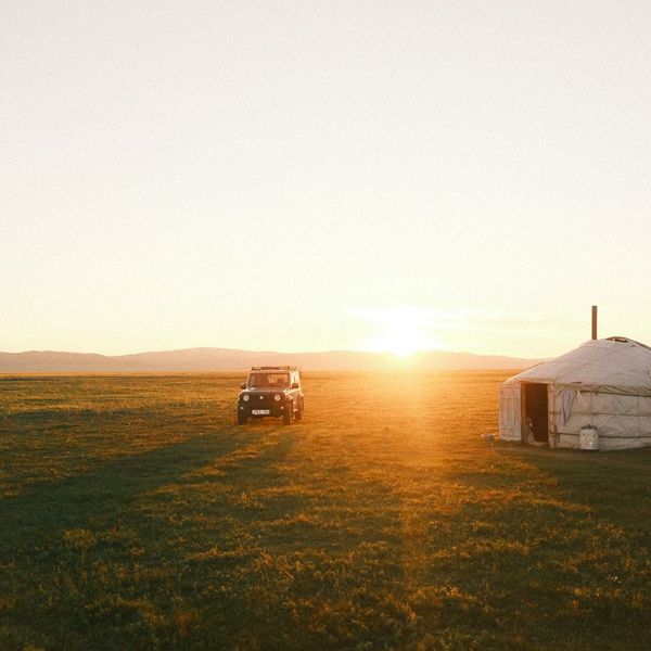 Coucher de soleil sur une yourte et un 4x4 au milieu de la steppe