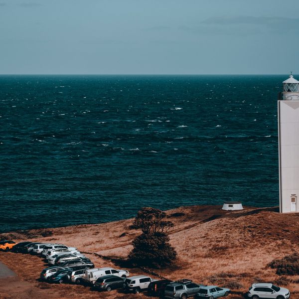 Phare moderne blanc s'élevant sur une pointe herbeuse face à l'immensité de l'océan à Cape Jervis