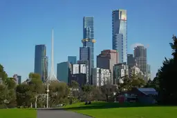 Gratte-ciels du centre-ville de Melbourne et flèche de l'Arts Centre vus depuis les pelouses verdoyantes des jardins botaniques.