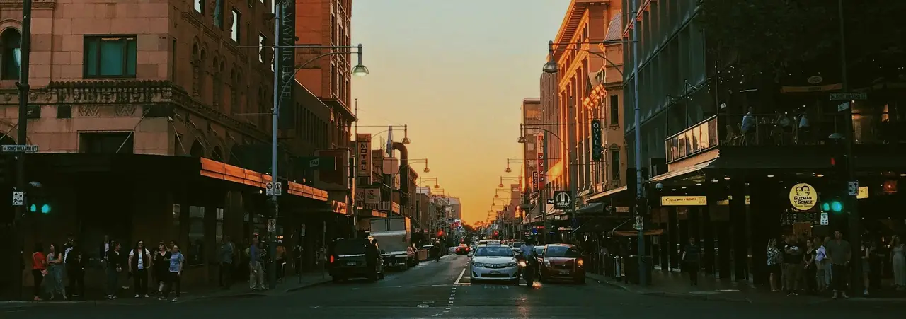 Perspective d'une avenue animée d'Adélaïde s'étendant vers un coucher de soleil doré