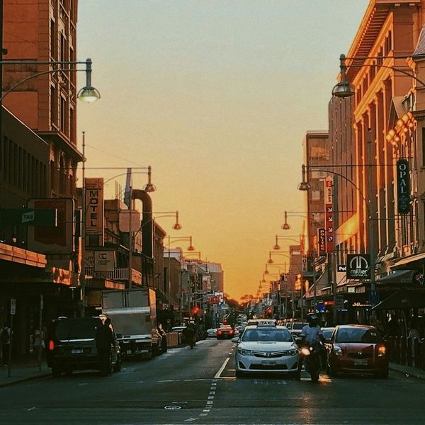 Perspective d'une avenue animée d'Adélaïde s'étendant vers un coucher de soleil doré