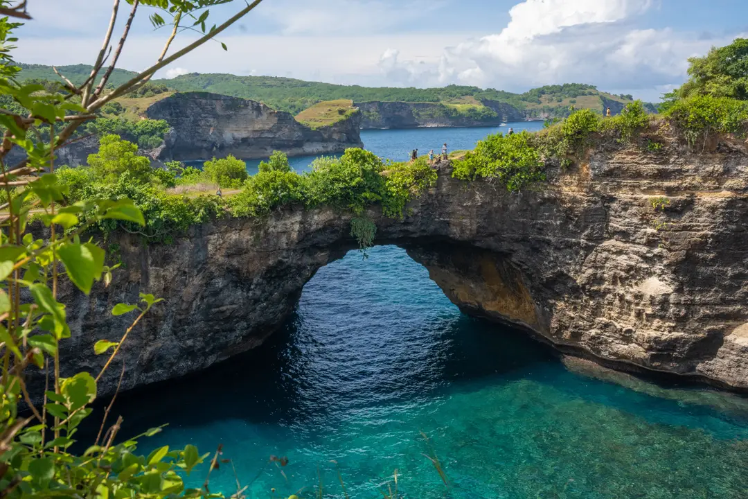 Voyage à Bali – Vue sur l'immense arche de pierre naturelle de Broken Beach encerclant une piscine marine aux eaux turquoise transparentes à Nusa Penida.