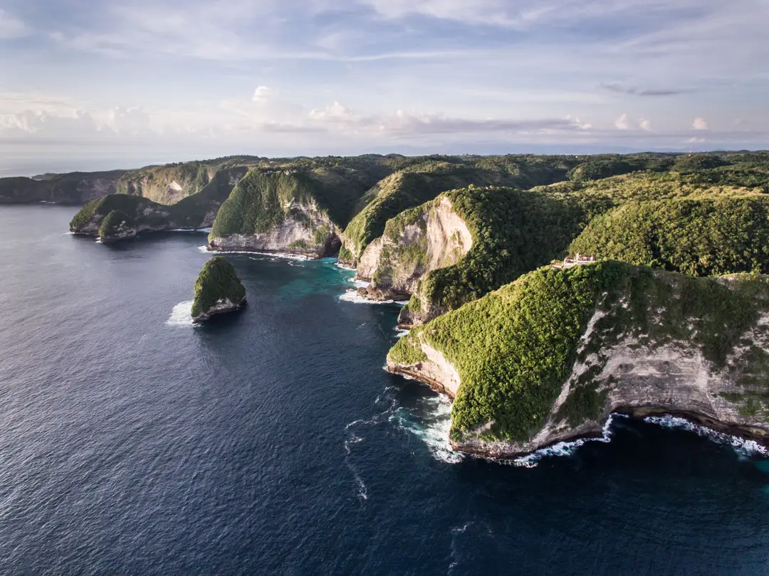 Voyage en Indonésie – Vue panoramique aérienne sur les impressionnantes falaises côtières abruptes couvertes de végétation de l'île de Nusa Penida près de Bali.