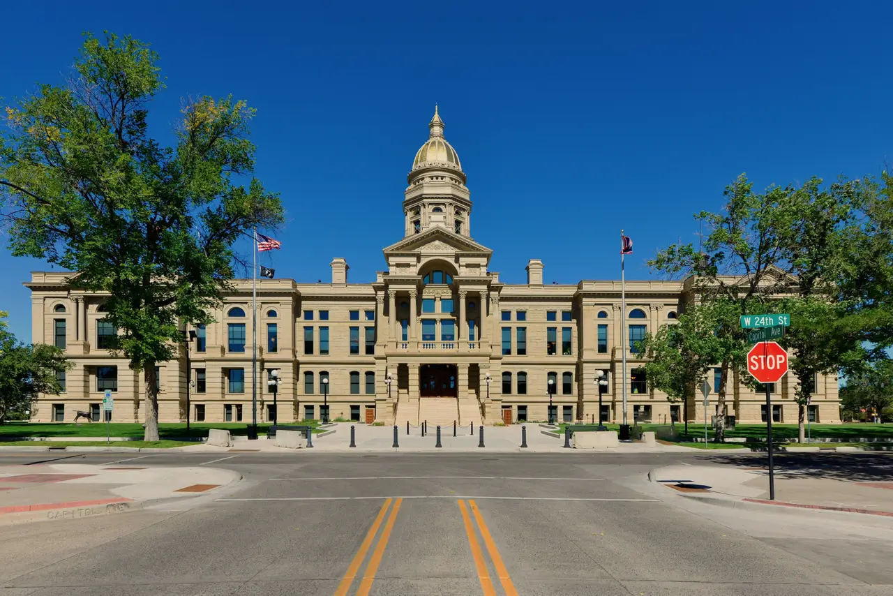 Façade du Capitole de l'État du Wyoming surmontée de son dôme doré sous un ciel bleu dégagé à Cheyenne