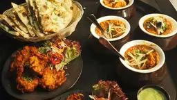 Voyage en Inde — Assortiment de plats traditionnels d'Inde du Nord, incluant naans, currys et spécialités épicées.