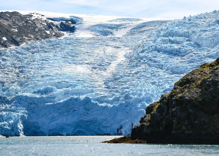 Front glaciaire aux nuances bleutées descendant des montagnes rocheuses vers les eaux de Valdez en Alaska