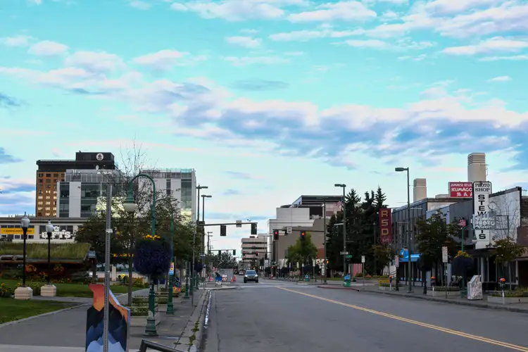 Rue bordée de bâtiments urbains dans le centre-ville d'Anchorage sous un ciel bleu nuageux en Alaska
