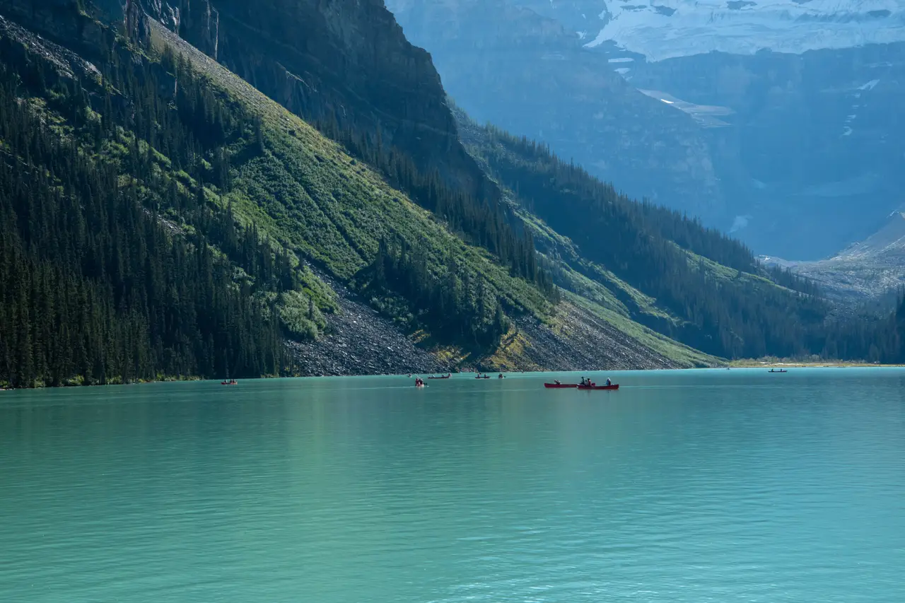 Eaux turquoise et calmes bordées de versants montagneux abrupts et boisés le long de la route entre Jasper et le lac Louise