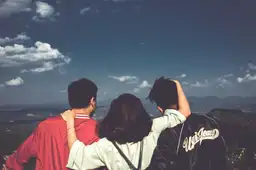 Trois jeunes voyageurs observant un panorama de montagnes brumeuses au Vietnam