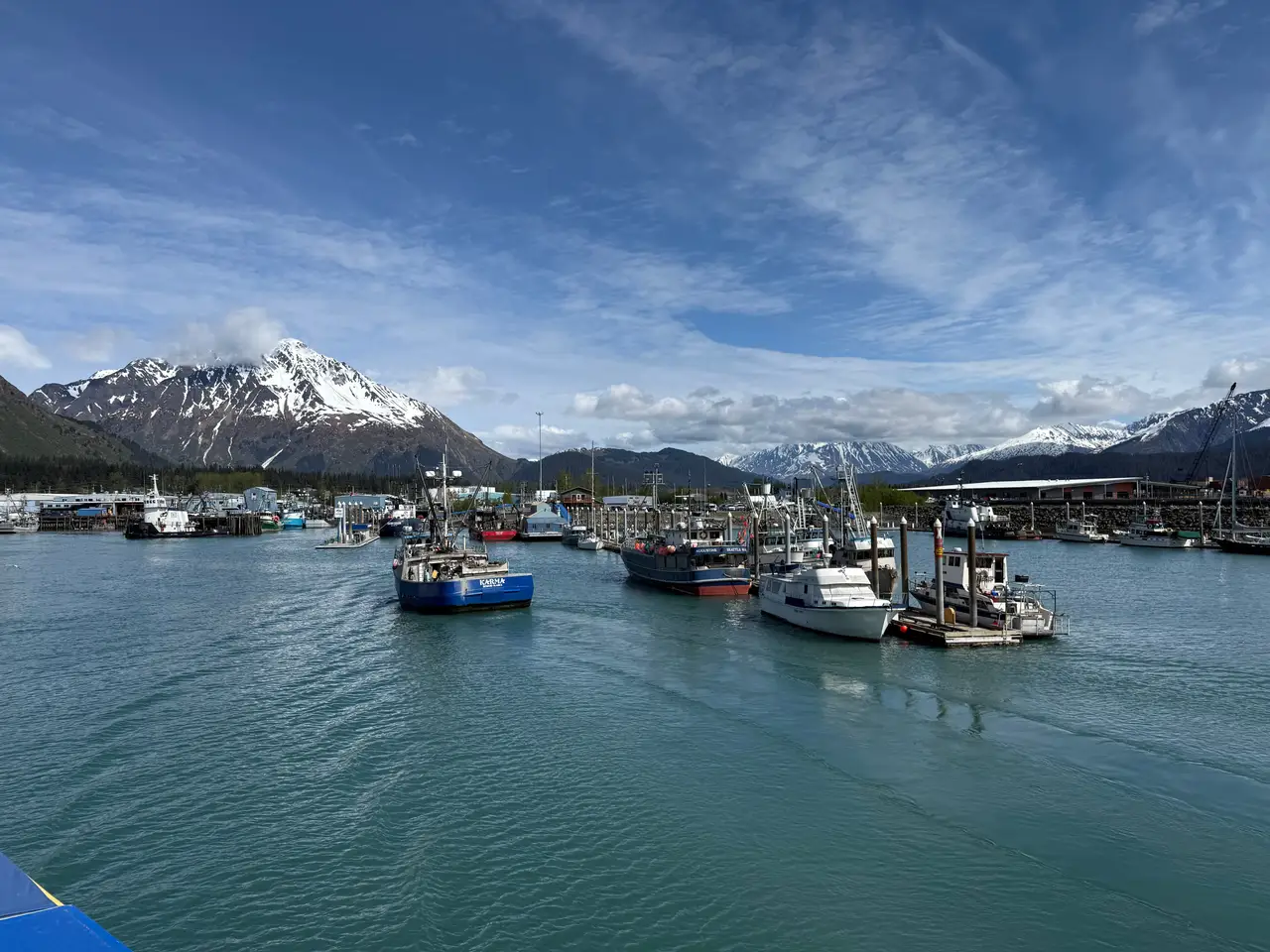 Bateaux de pêche amarrés dans le port de Seward devant les eaux calmes et les montagnes aux sommets enneigés de la péninsule de Kenai
