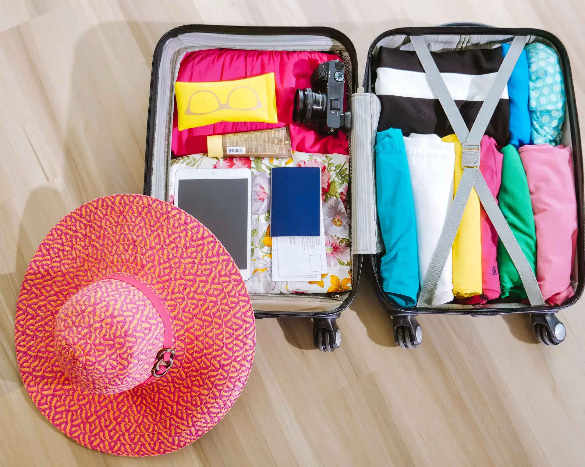 Préparer sa valise pour Bali – Valise ouverte et organisée avec des vêtements d'été légers, des accessoires de voyage et un chapeau de paille.