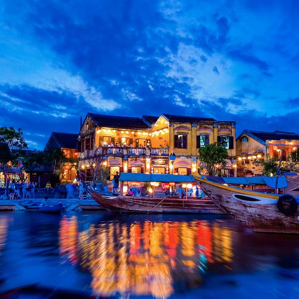 Voyage au Vietnam — Scène nocturne du Vieux Quartier de Hôi An avec lanternes colorées, maisons anciennes et reflets lumineux sur la rivière Thu Bồn.