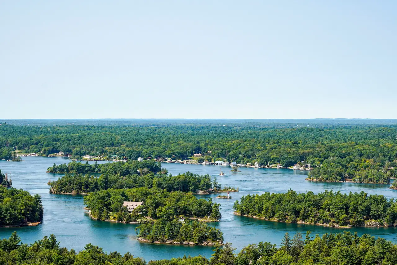 Vue aérienne panoramique sur les îles verdoyantes et boisées de l'archipel des Mille-Îles entourées d'eaux calmes sous un ciel dégagé