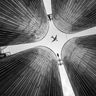 Travel in Asia - Low-angle perspective looking up at four large pillars, arranged to frame a single airplane flying overhead