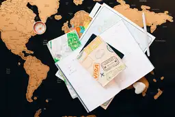 Passeport, documents de voyage et boussole posés sur une carte du monde préparés pour les formalités de séjour.