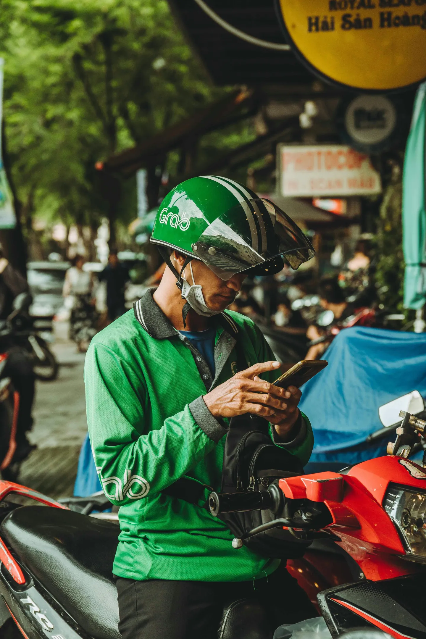 Voyage au Vietnam — chauffeur xe ôm Grab utilisant une application mobile pour le transport moto-taxi en ville