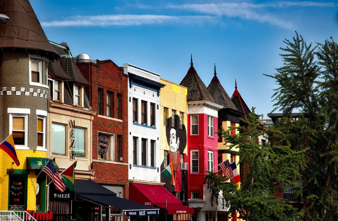 Rond-point ou alignement de maisons de ville historiques et colorées en briques de style victorien avec drapeaux et escaliers à Washington DC