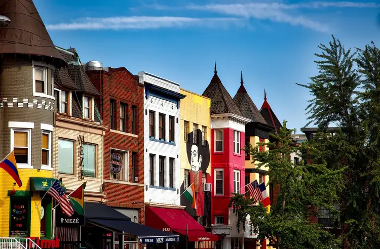 Rond-point ou alignement de maisons de ville historiques et colorées en briques de style victorien avec drapeaux et escaliers à Washington DC
