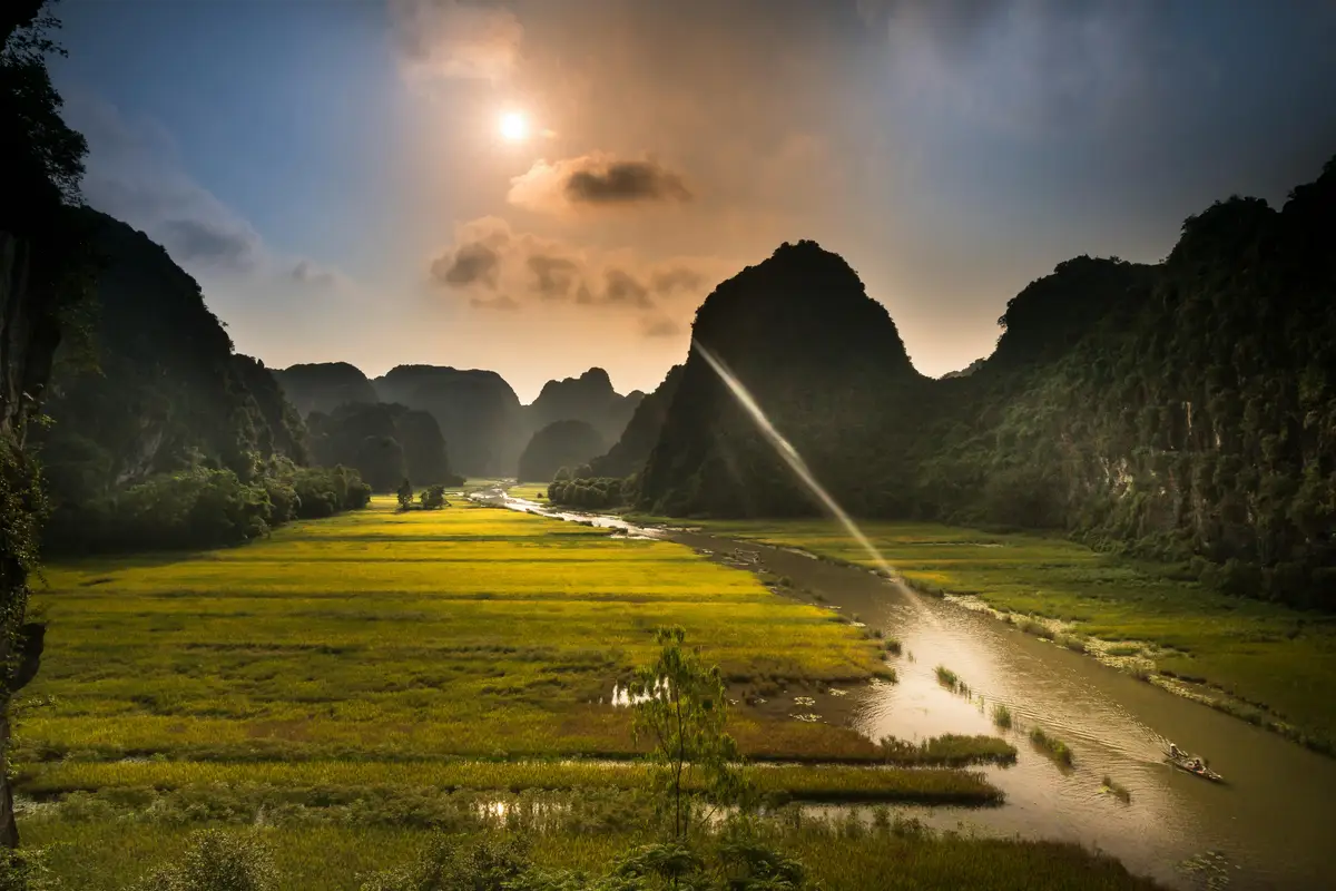 Voyage au Vietnam — Paysage de rizières et formations karstiques dans le Nord Vietnam sous une lumière dorée.