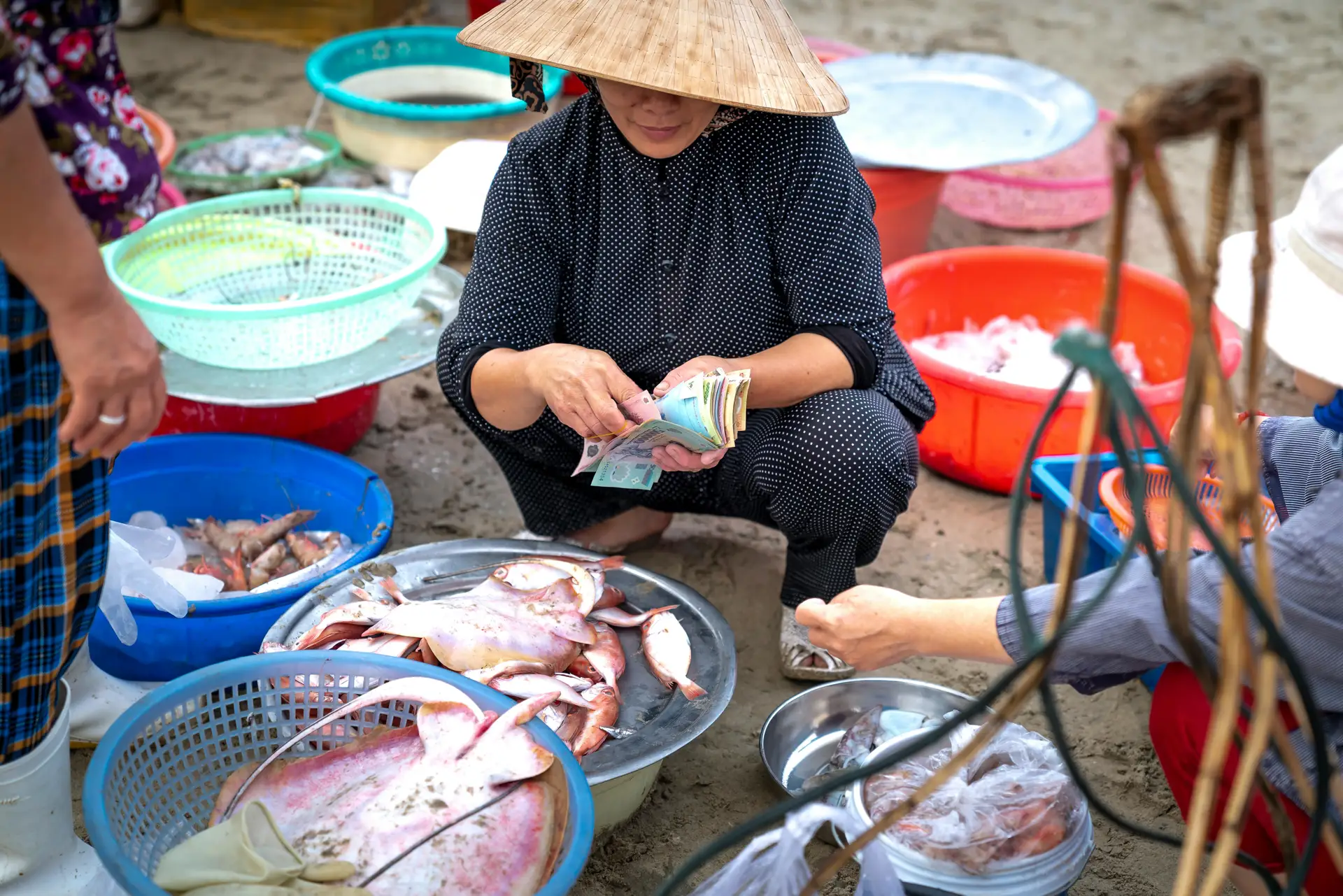 Femme vietnamienne sur un marché local vendant des produits frais, illustration de la vie quotidienne au Vietnam.