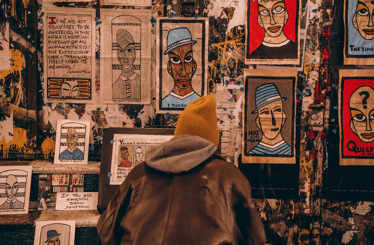 Mur couvert d'affiches illustrées de portraits artistiques et colorés de style street art dans une rue de New York