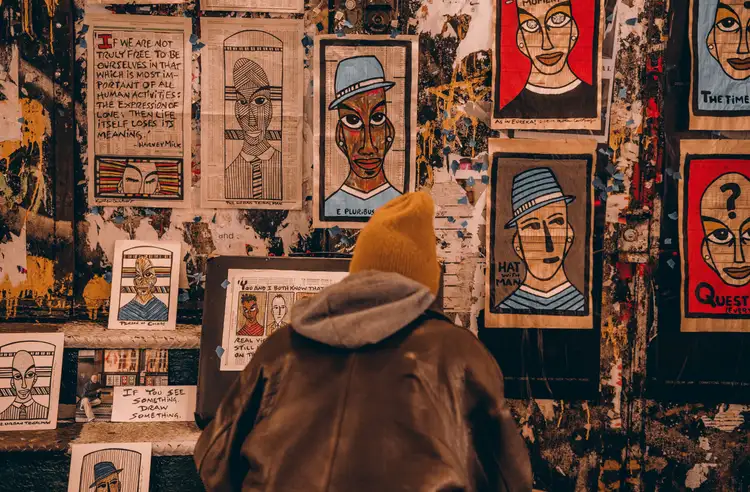 Mur couvert d'affiches illustrées de portraits artistiques et colorés de style street art dans une rue de New York