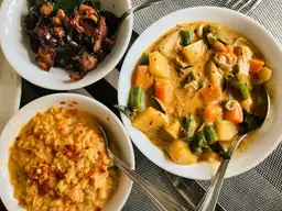 Assortiment de bols de curry sri lankais traditionnels, incluant dhal de lentilles et curry de légumes colorés.