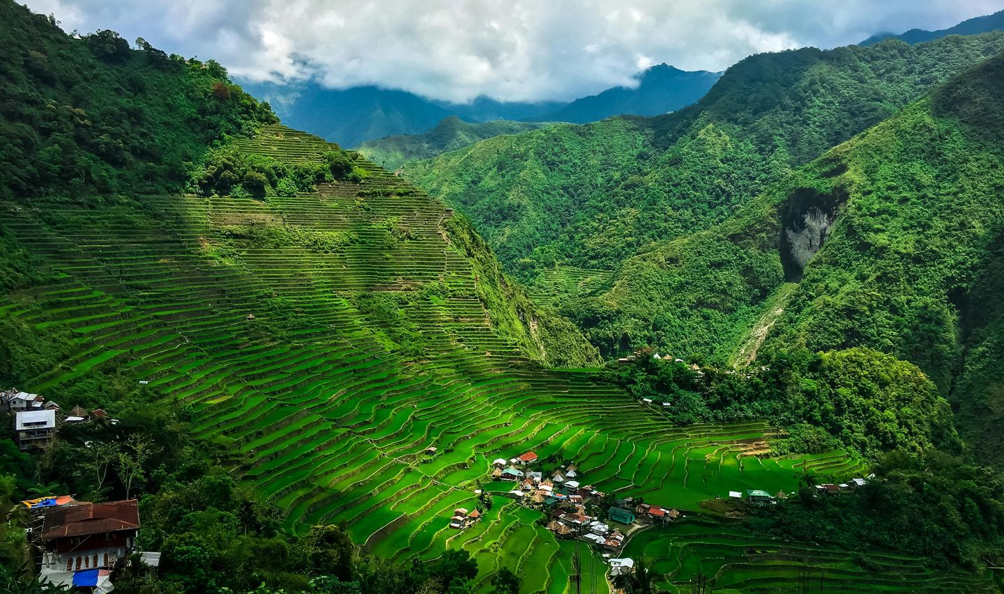 Travel in the Philippines — The iconic, vibrant green rice terraces of Banaue descending steep mountainsides, observed from a high vantage point