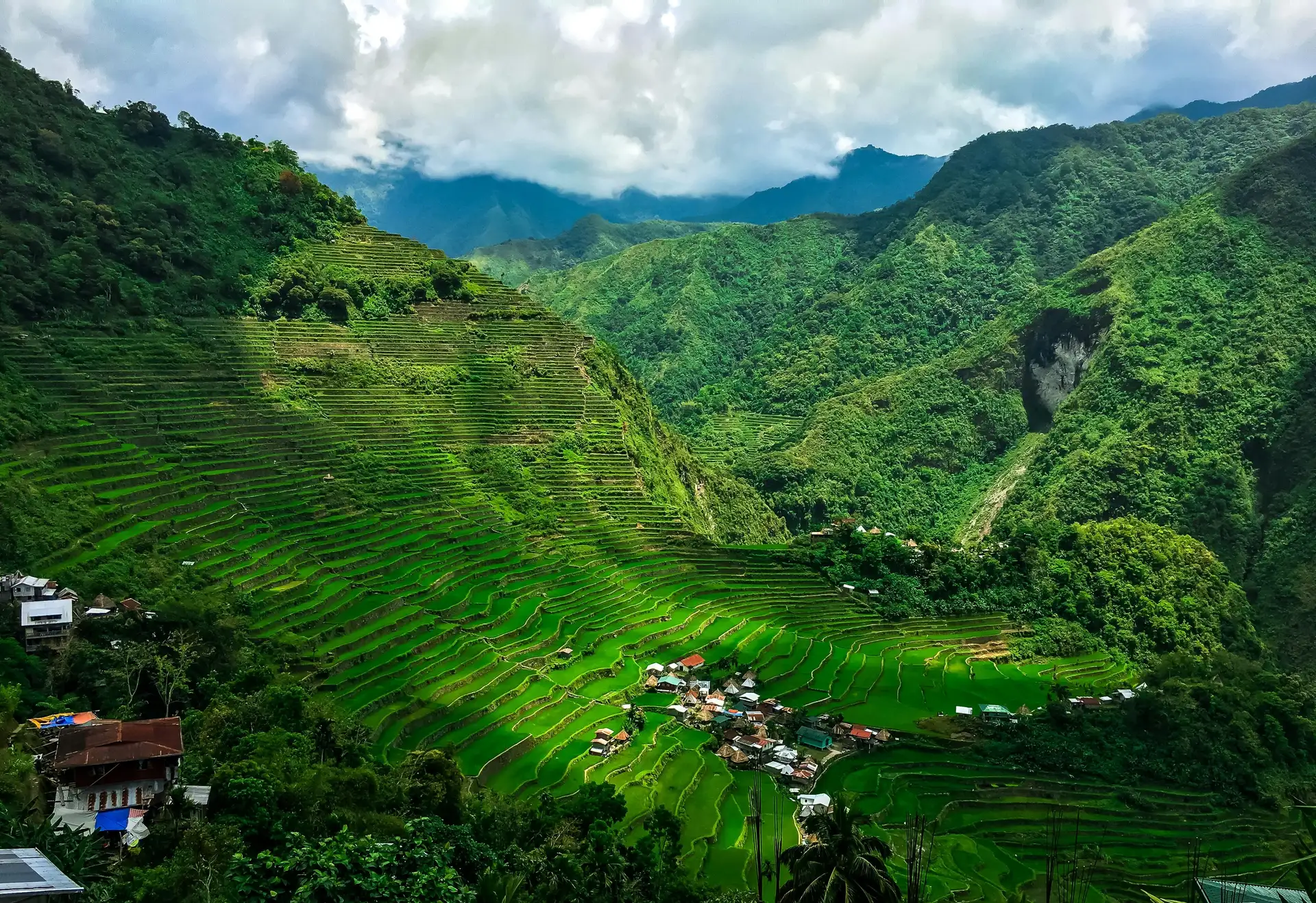 Travel in the Philippines — The iconic, vibrant green rice terraces of Banaue descending steep mountainsides, observed from a high vantage point