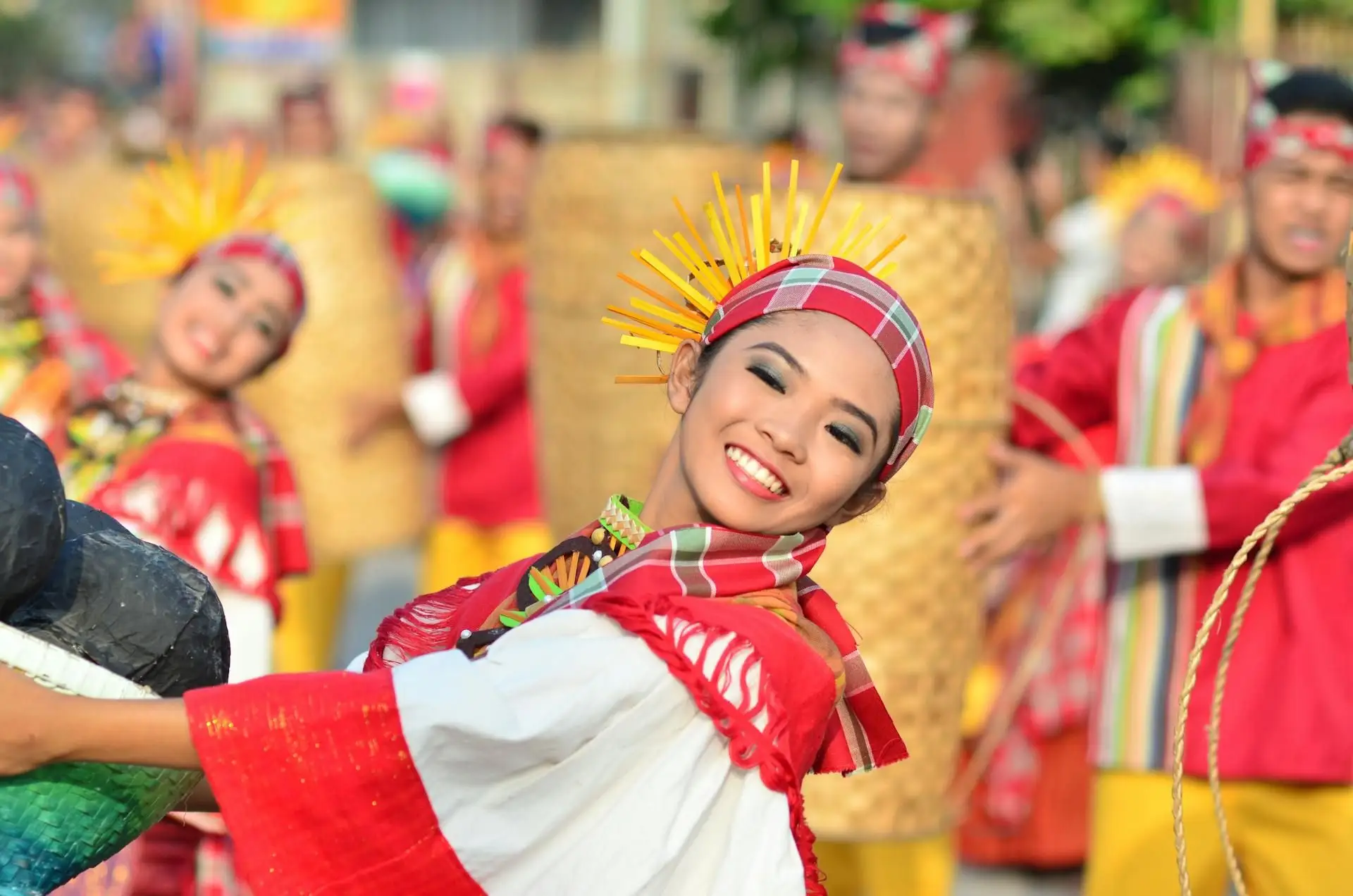 Travel in the Philippines — Smiling female cultural dancer wearing vibrant traditional festival attire during a lively local fiesta celebration in Luzon.