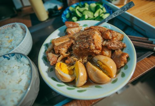 Travel in the Philippines — A traditional plate of Filipino pork adobo with soy-braised eggs and steamed rice, reflecting local cuisine.