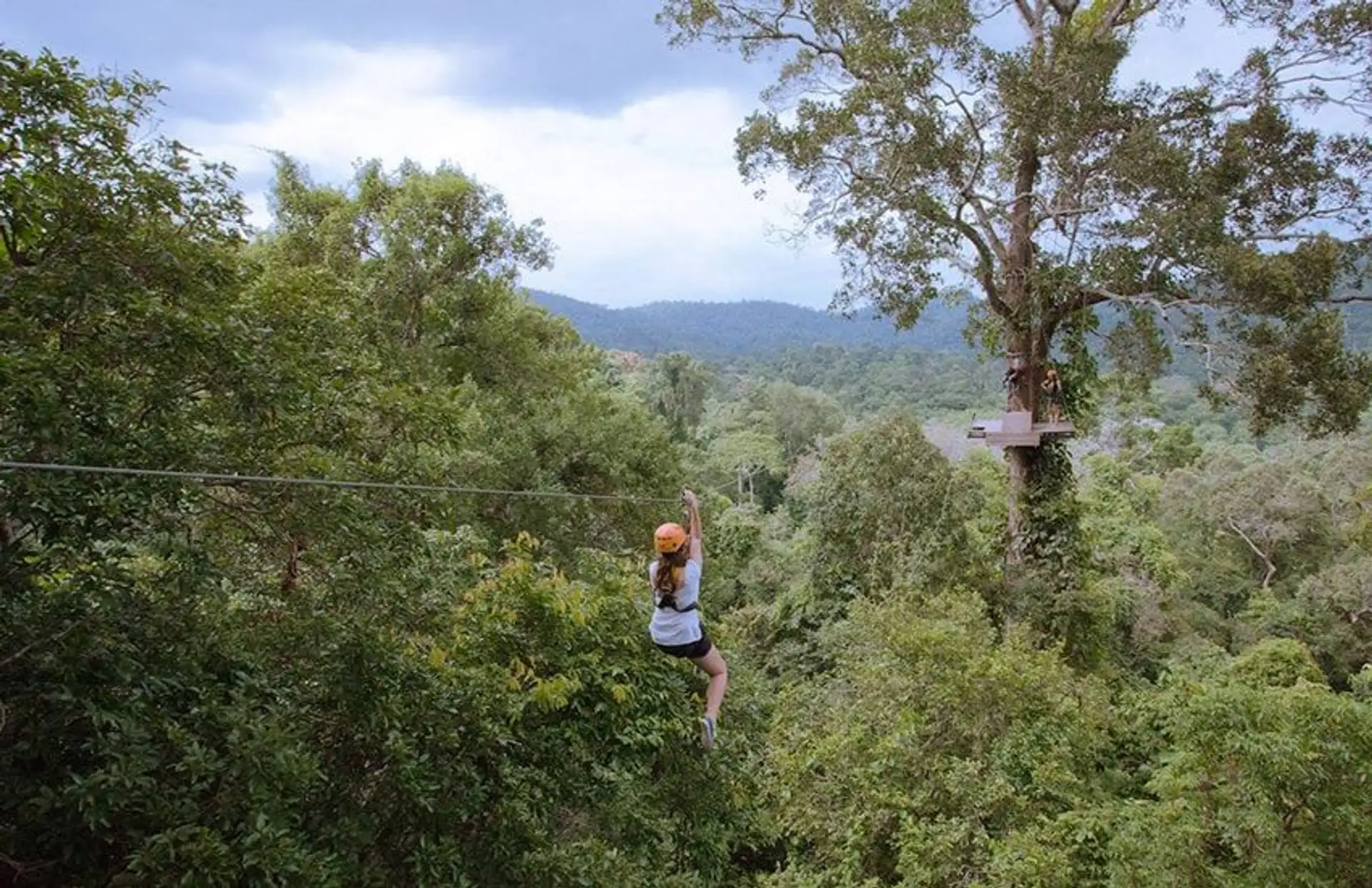Adventure travellers zip-lining and rock-climbing near ancient Khmer temples in Cambodia – an immersive experience of nature, culture and thrills.