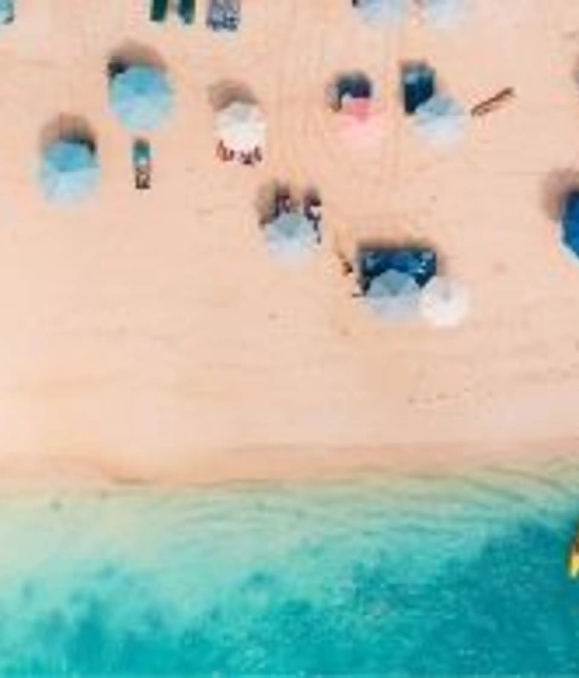 Travel in Asia - Aerial view of beachgoers relaxing on a Bali beach