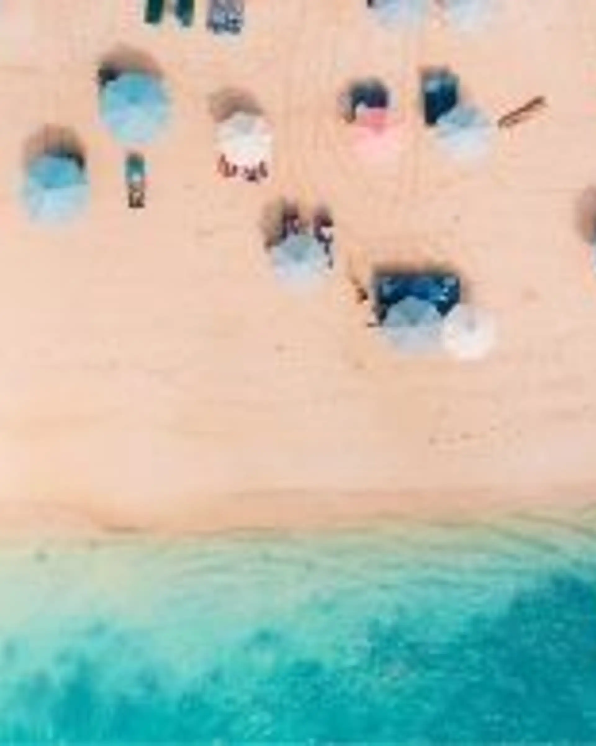Travel in Asia - Aerial view of beachgoers relaxing on a Bali beach
