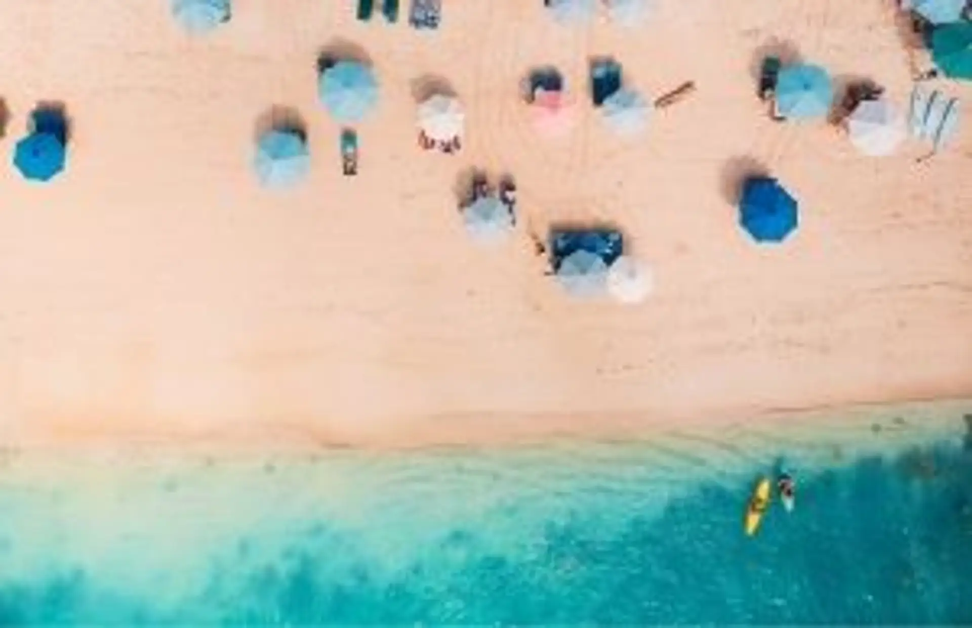 Travel in Asia - Aerial view of beachgoers relaxing on a Bali beach