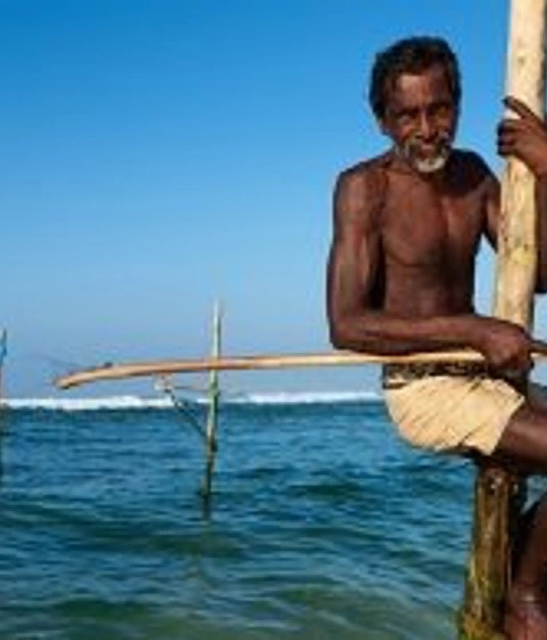 Travel in Asia - A man stilt fishing on a beach in Sri Lanka
