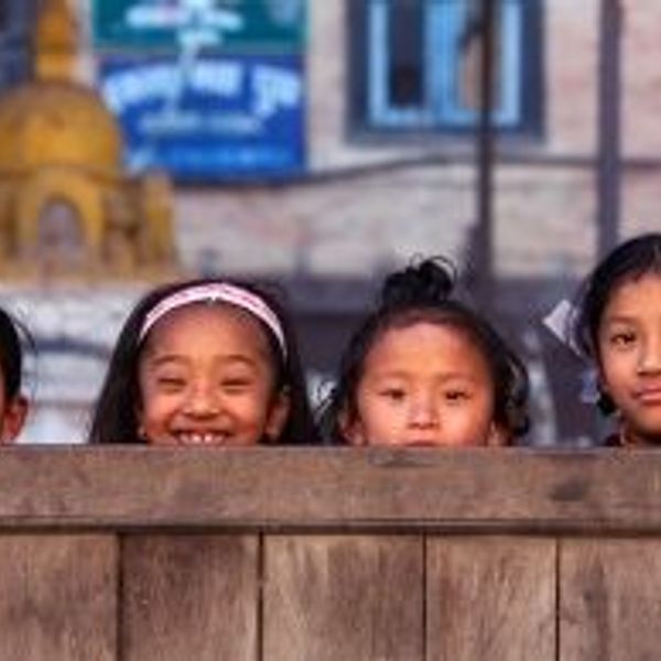 Travel in Asia - Four young smiling Nepalese girls playing hide and seek with the camera