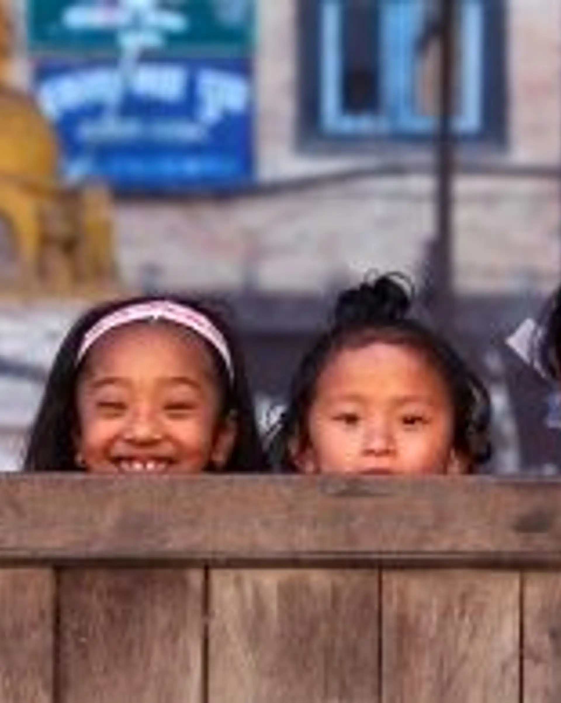 Travel in Asia - Four young smiling Nepalese girls playing hide and seek with the camera