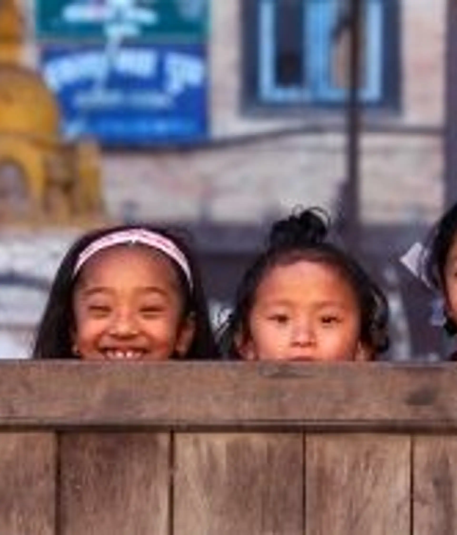 Travel in Asia - Four young smiling Nepalese girls playing hide and seek with the camera