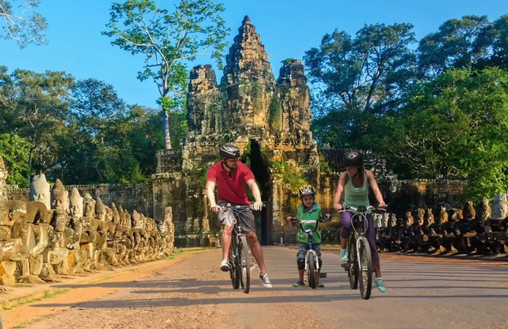Travel in Asia - Happy family exploring Khmer temples of Angkor Wat by bicycle in Cambodia