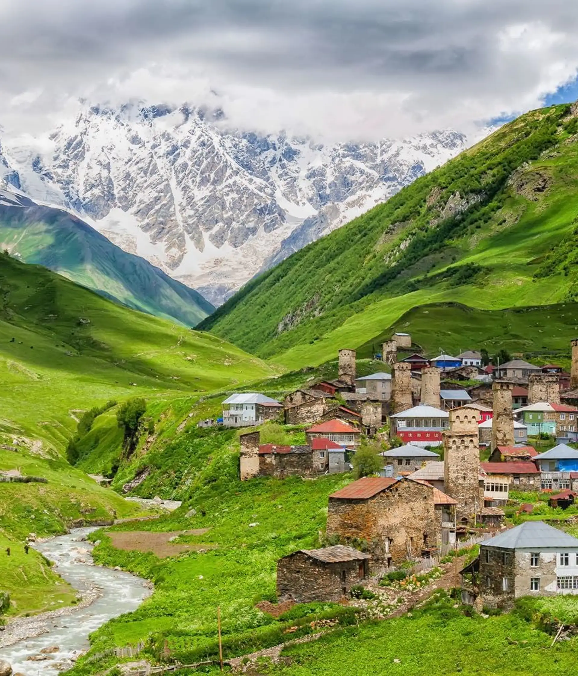 Village typique de Haute Svanétie avec ses tours médiévales au pied de sommets enneigés du Caucase.