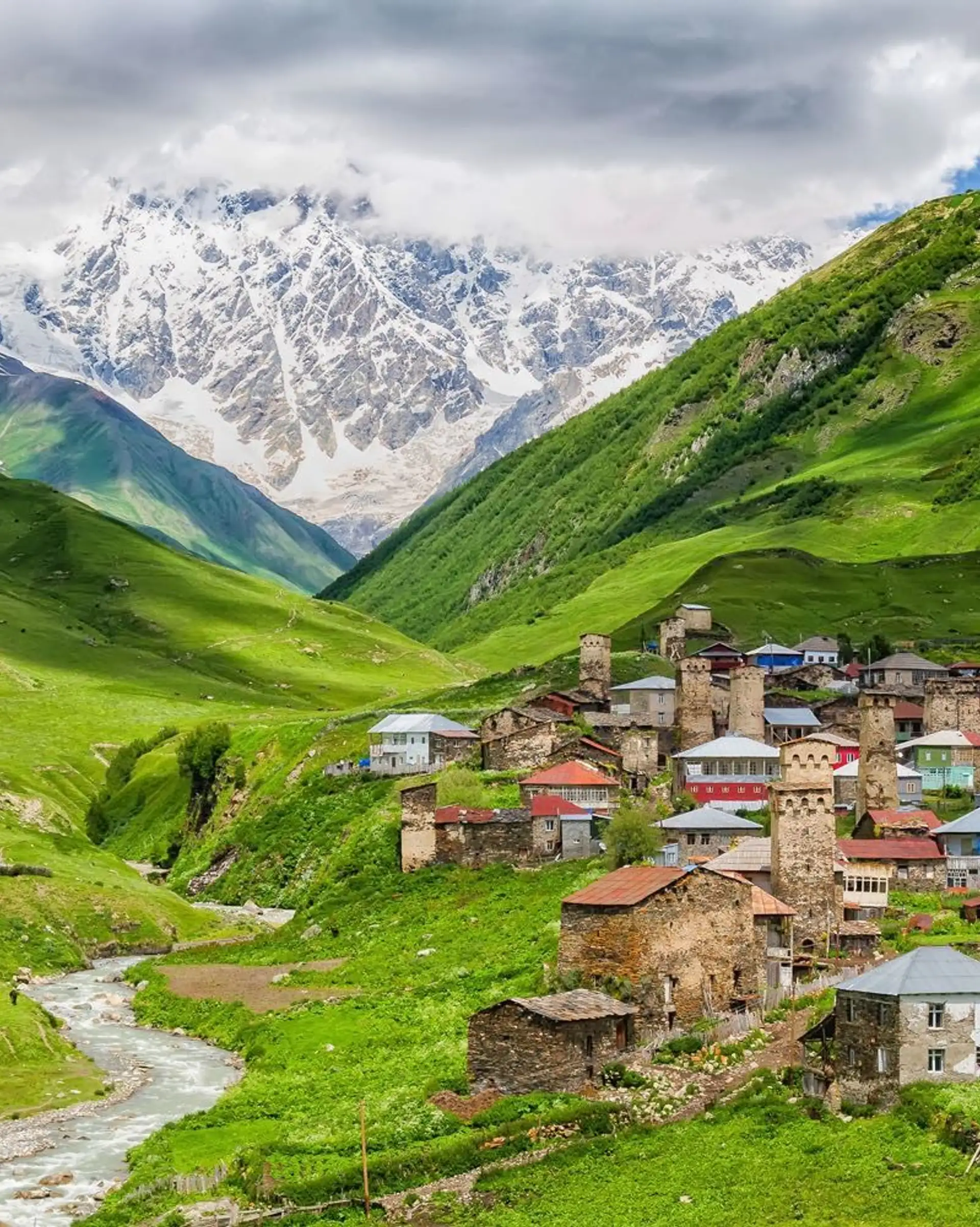 Village typique de Haute Svanétie avec ses tours médiévales au pied de sommets enneigés du Caucase.