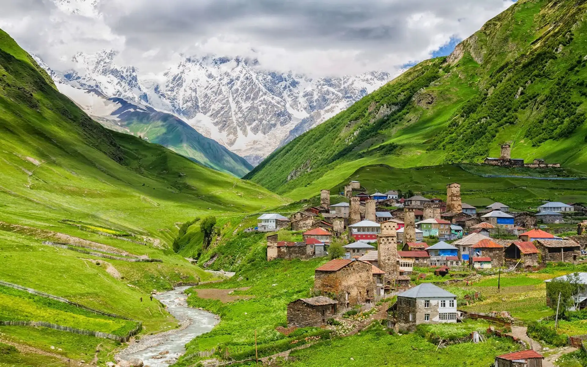 Village typique de Haute Svanétie avec ses tours médiévales au pied de sommets enneigés du Caucase.